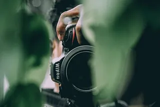 Kameraobjektiv durch Blätter.