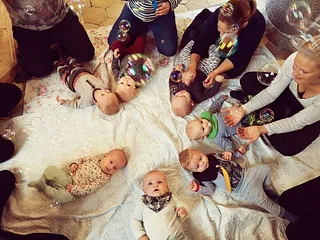 Viele Babys liegen auf einer Decke.